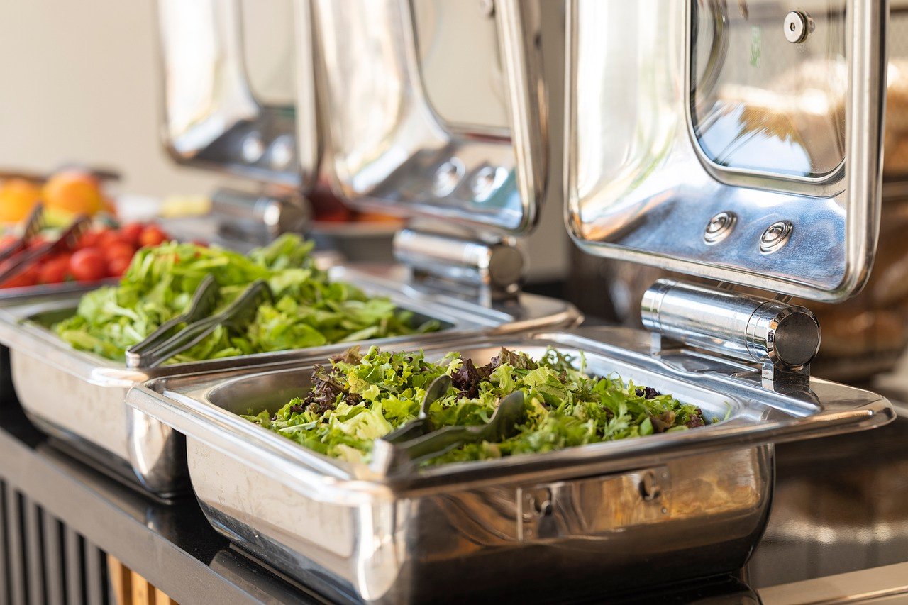 Chef carving meat under heat lamps at a buffet station